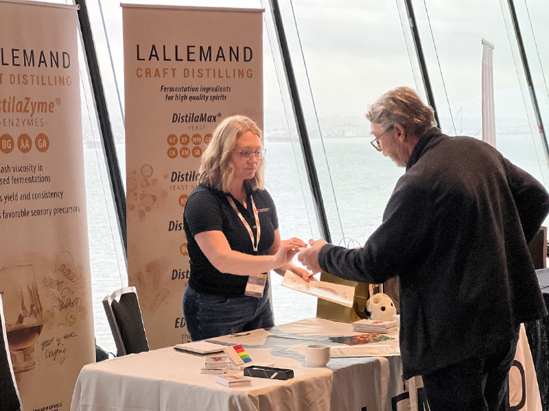Booth exhibitor speaking with attendee