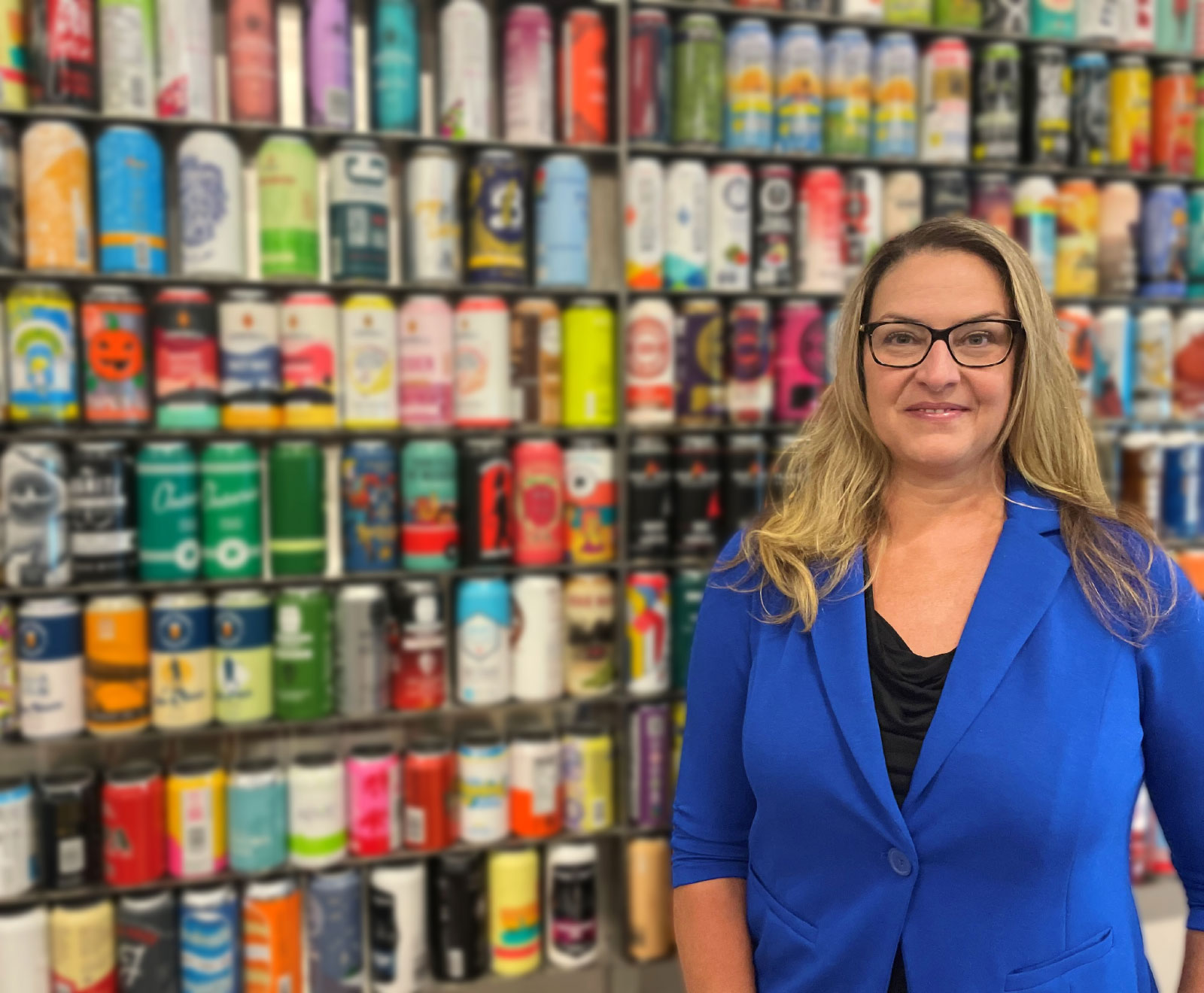Johanna smiling, leaning against stacks of cans
