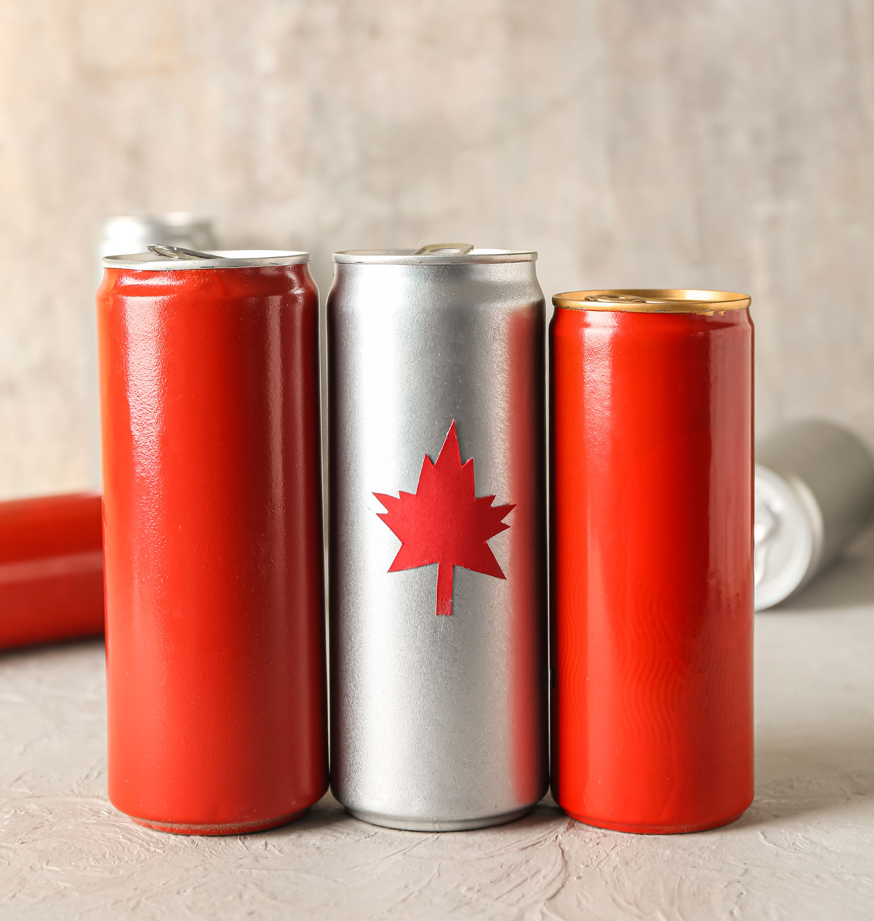 2 red cans and one silver one with a red maple leaf affixed to it