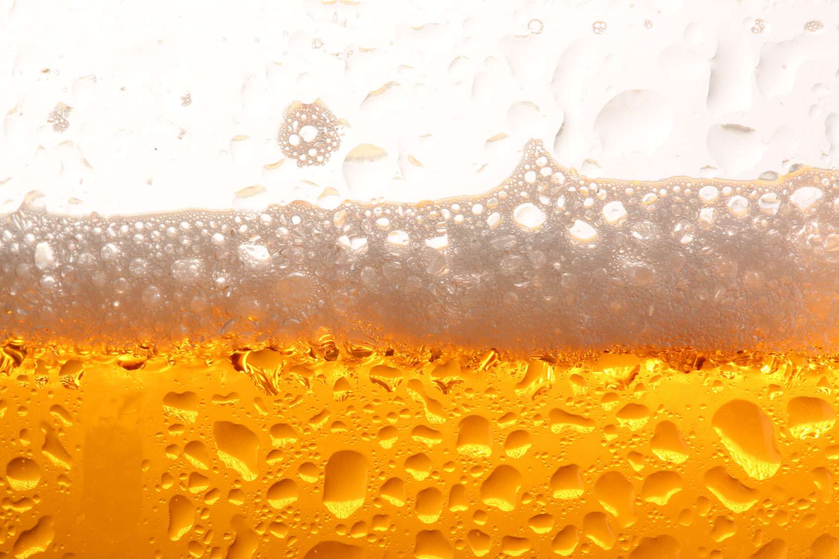 Extreme closeup of a bubbly beer with foam