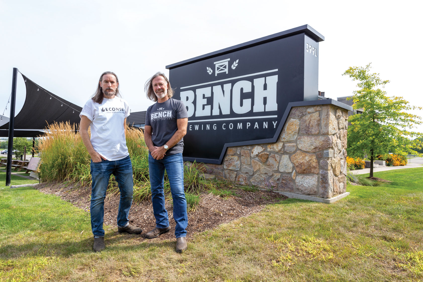 Derek Davy and Matt Griffen posing in front of Bench Brewing Company sign