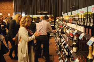 People looking at shelves stocked with wine bottles