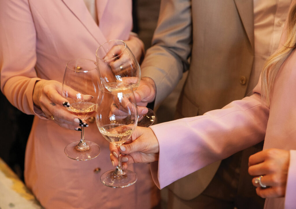 Three people clinking wine glasses