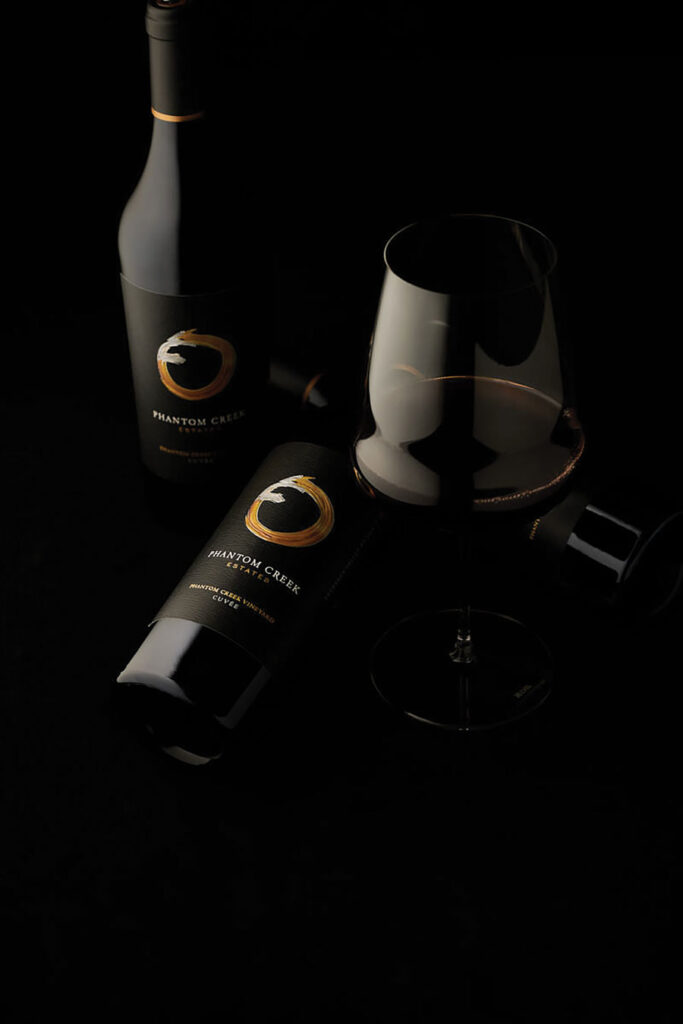 Bottles of Phantom Creek Estates wine and wine glass