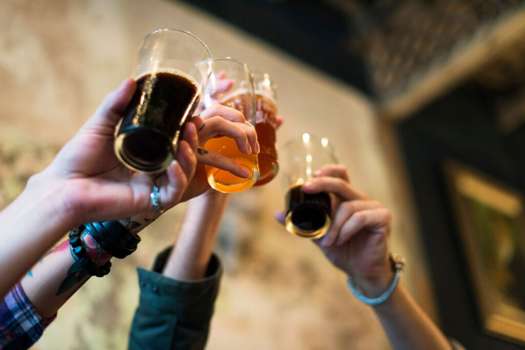 Three glasses of beer being raised for a toast