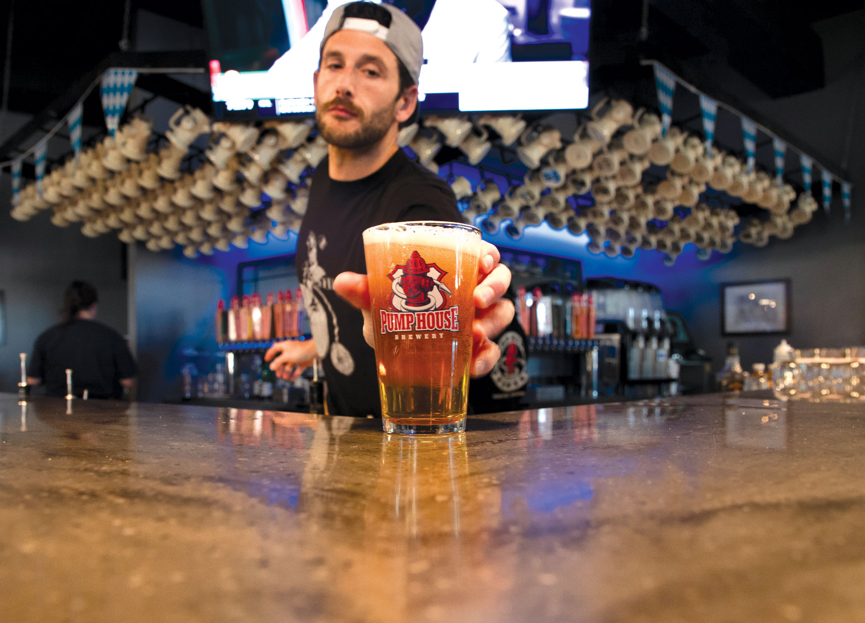 Bartender setting down freshly poured glass of beer