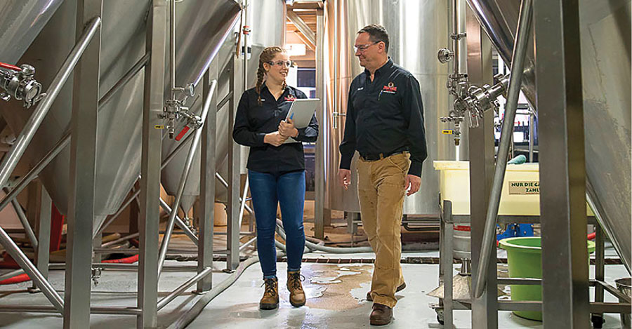 Man and woman walking through brewing facility