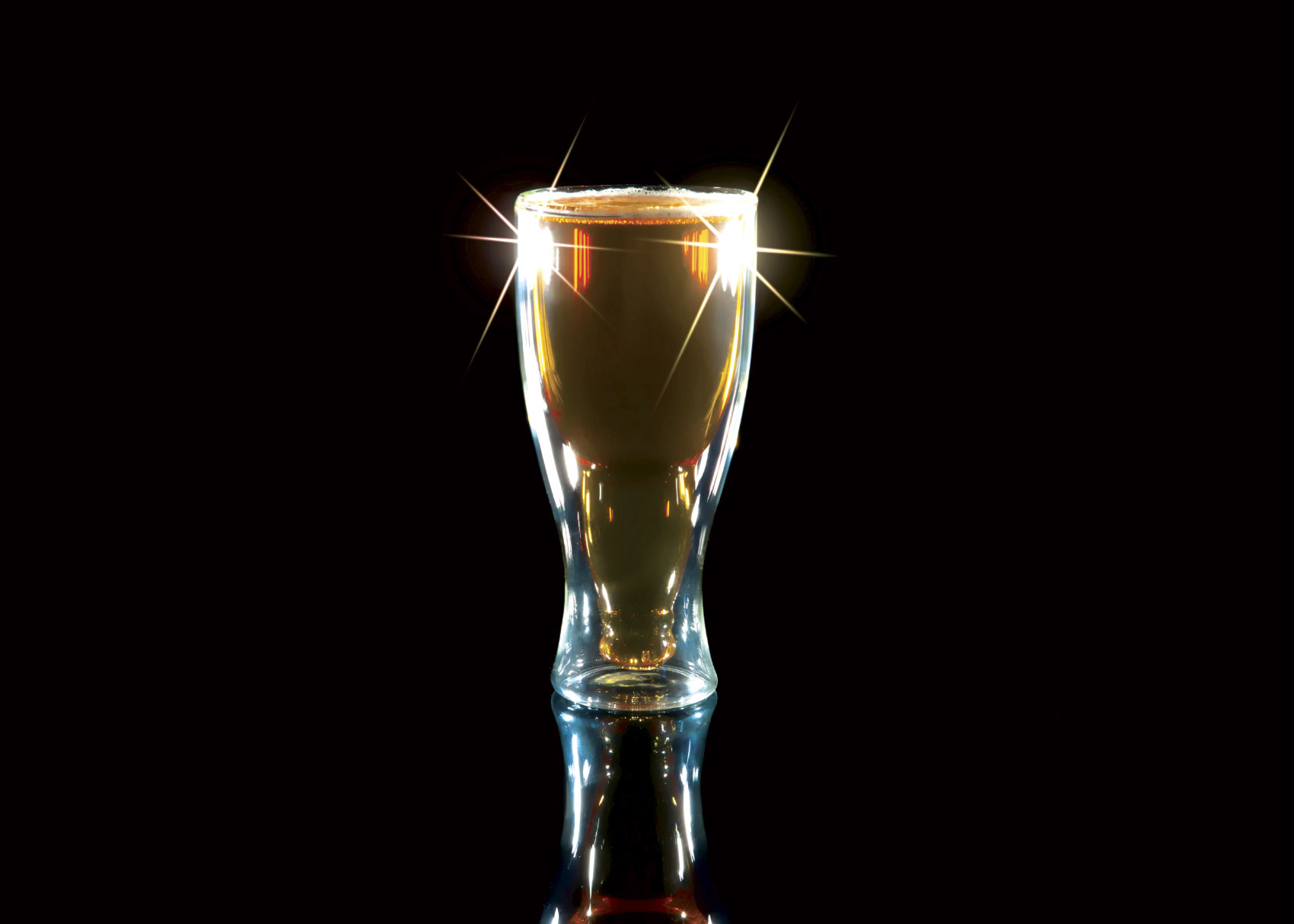 Glass of beer isolated against black background