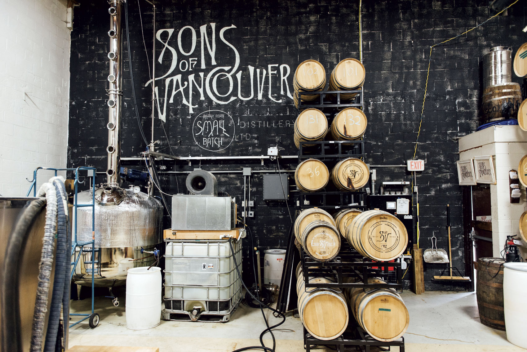 interior shot of Sons of Vancouver Distillery with wooden barrels and various distillery equipment