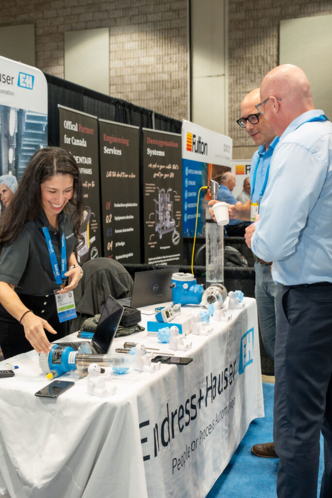 Attendees chatting with vendor at vendor booth