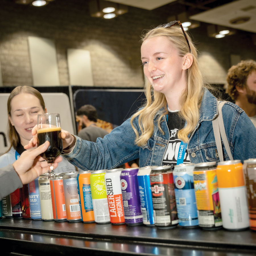 Attendee smiling, being given a dark beer