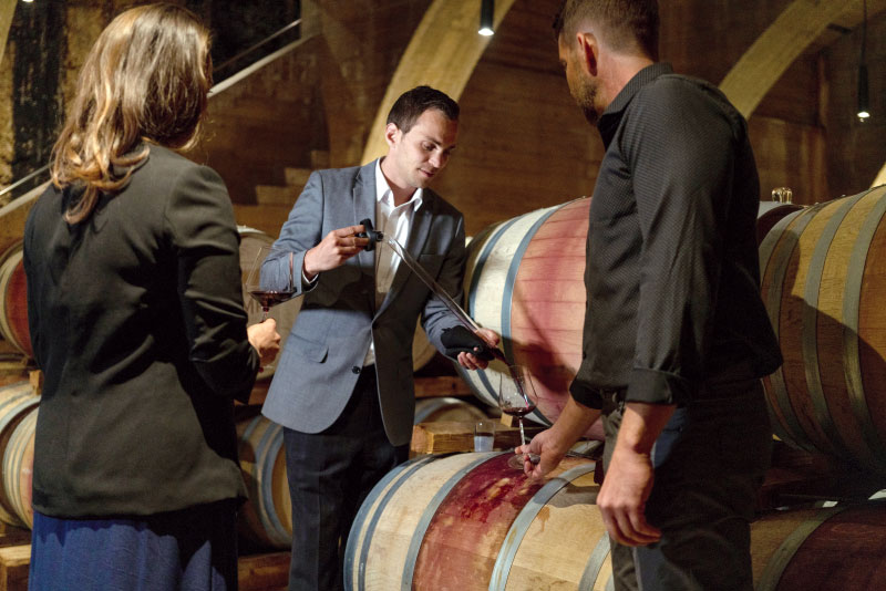 Sommelier extracting wine from barrel for tasting