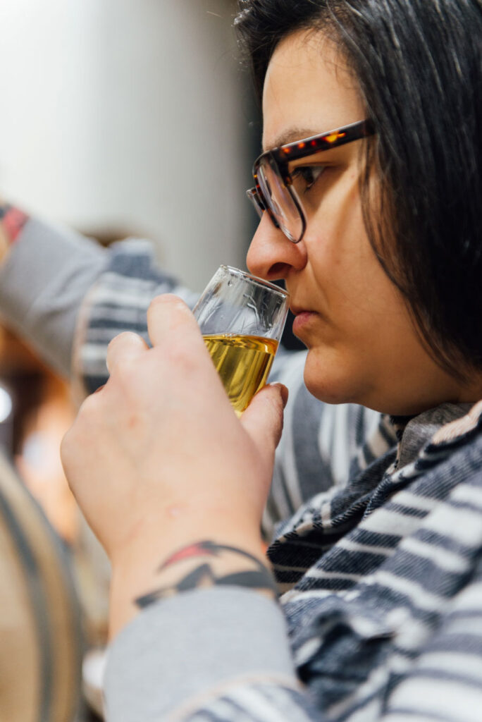 Woman smelling whisky, glass in hand