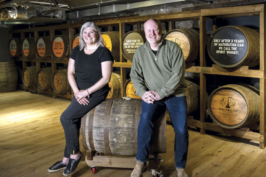 Kelly and Rob Carpenter sitting on barrel, smiling