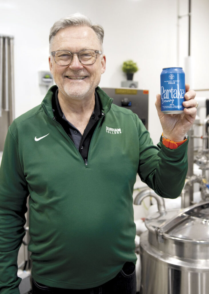 Chris holding can of Partake Brewing Pale