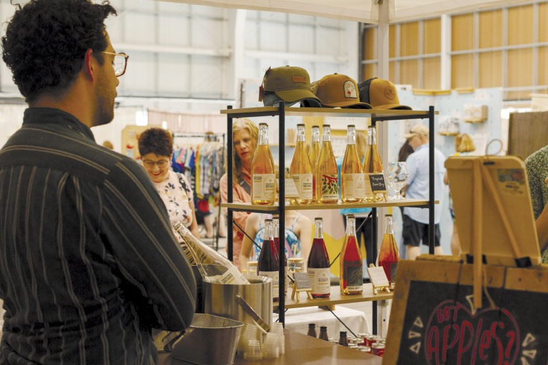 Vendor looking out at attendees with various product on display