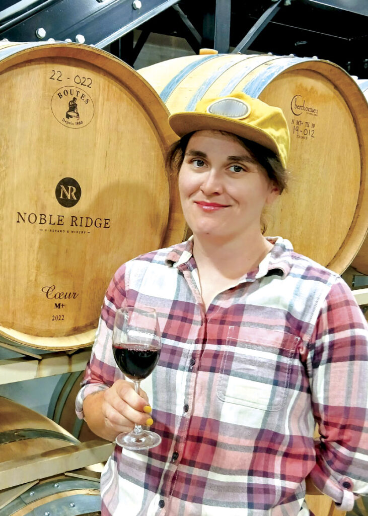 Libby Nixon posing for photo with branded barrels in background
