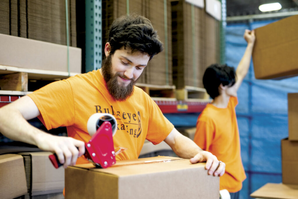 Man with sealing box with packing tape for shipping