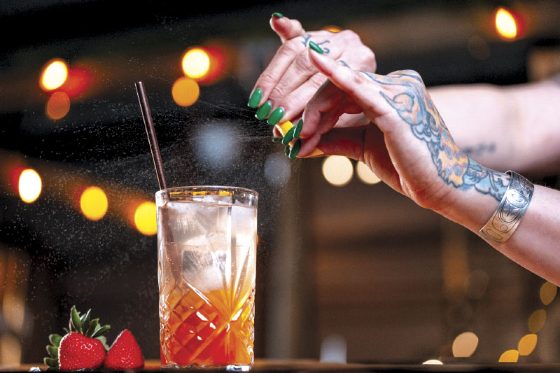 Squeezing citrus in a strawberry cocktail