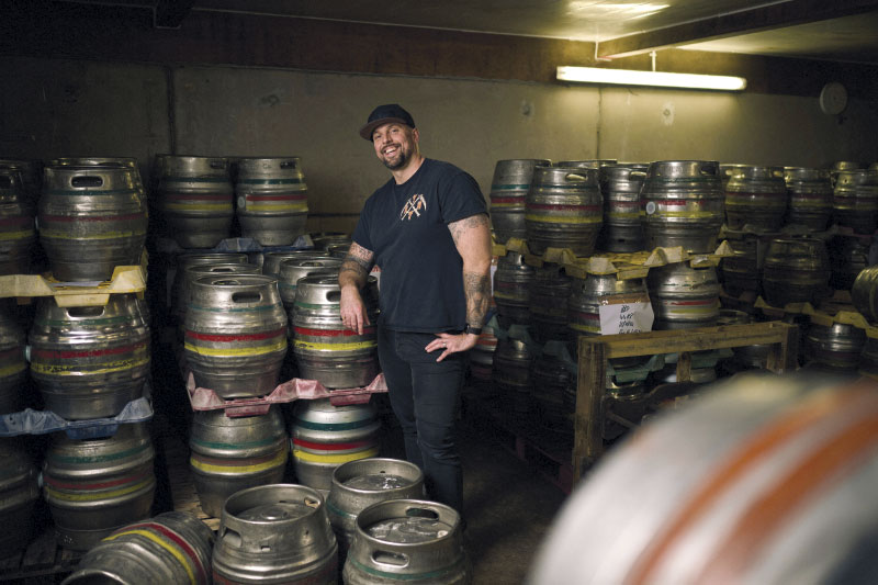 Tim Weaver leaning against kegs