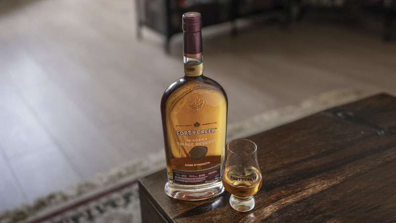 Bottle of Forty Creek Niagara Triple Reserve and snifter on wood table