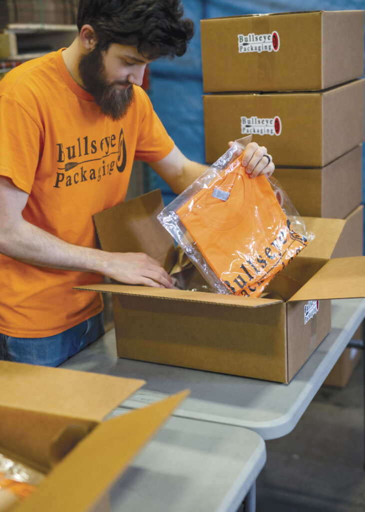 Packing orange brand shirts in boxes