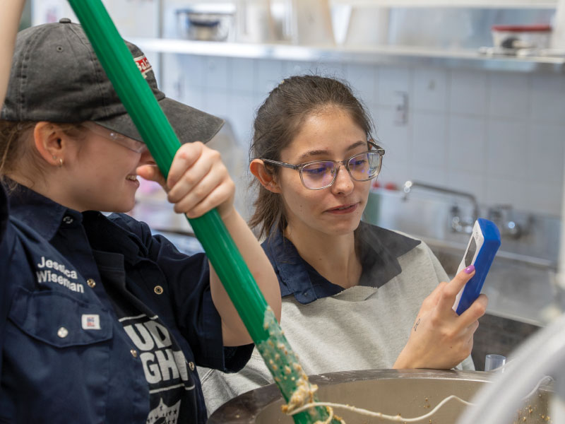 Students testing brew with handheld device