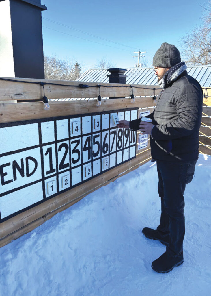 Graeme Maclean keeping score during a milk jug curling contest on Interlake Brewing’s rooftop patio