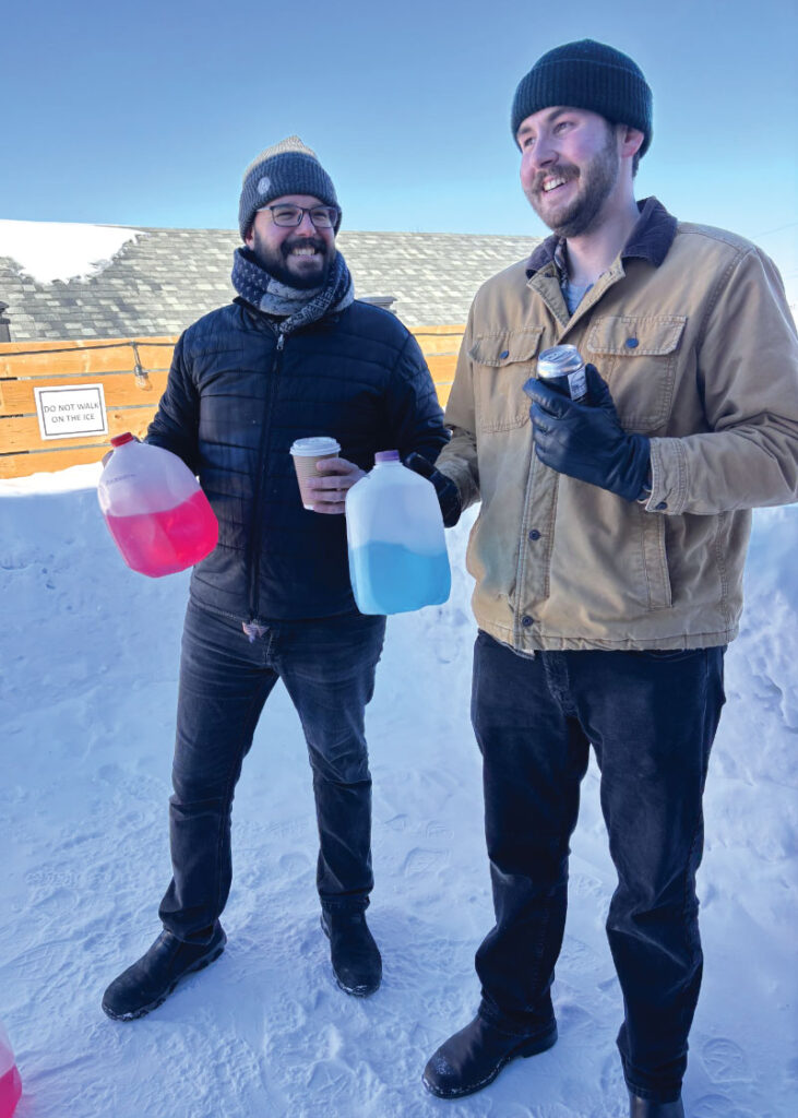 Graeme Maclean and Simon James on rooftop holding blue and red jugs