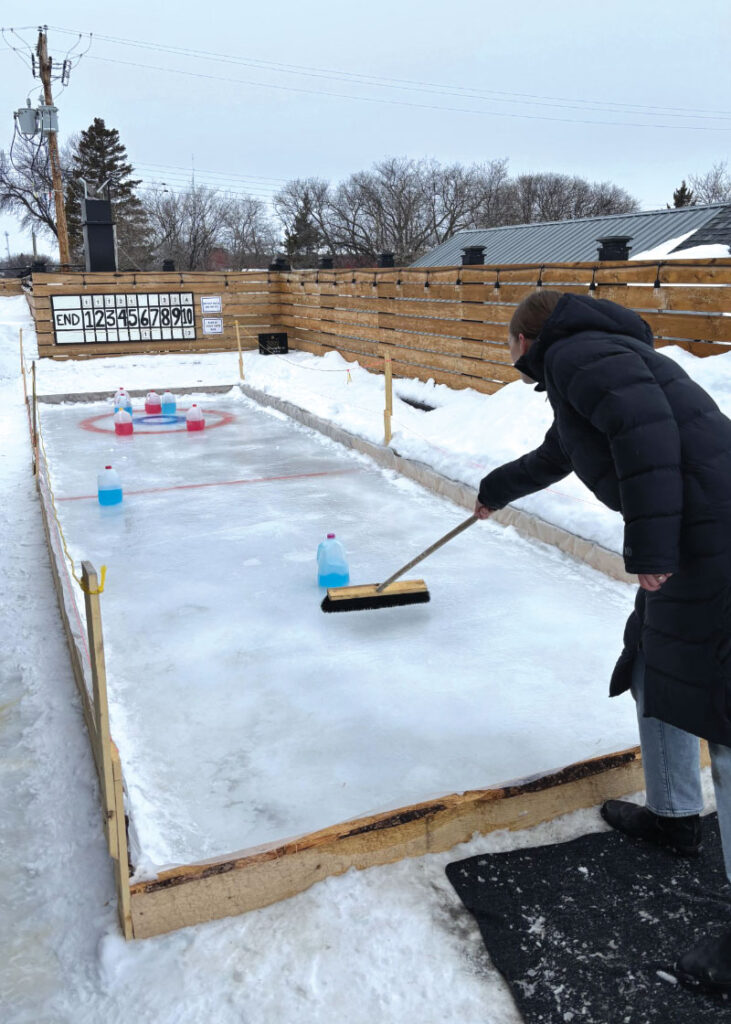 Heidi Arnbjornsson trying milk jug curling on rooftop patio