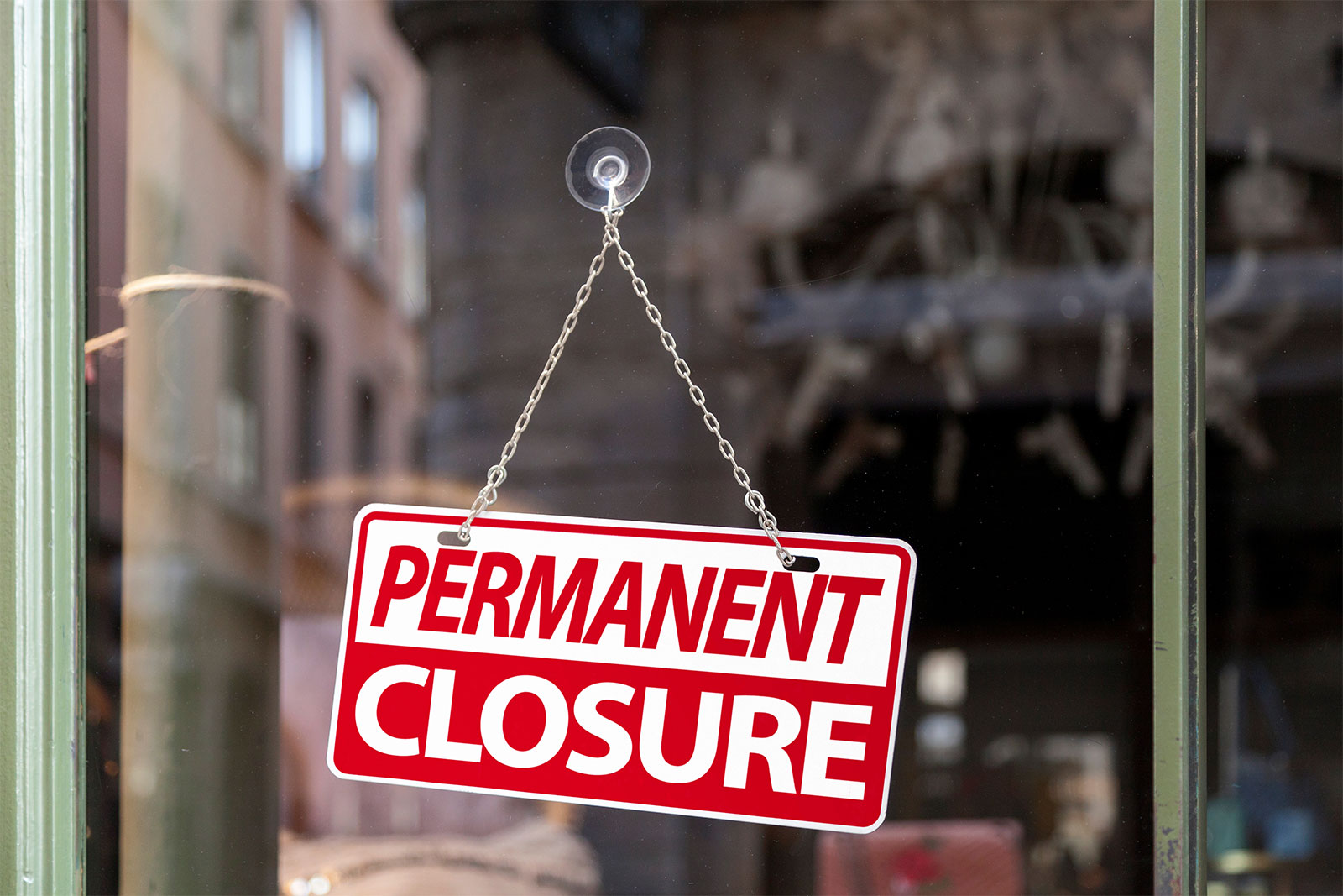 Permanent Closure sign hanging in a business window
