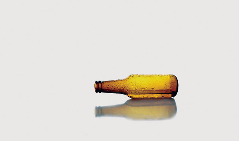 Empty beer bottle laying on its side