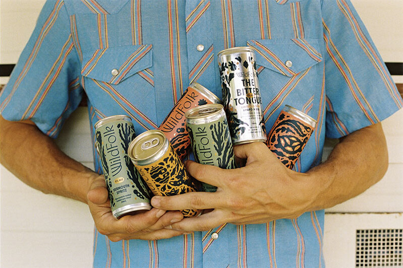 Man holding armful of canned beers