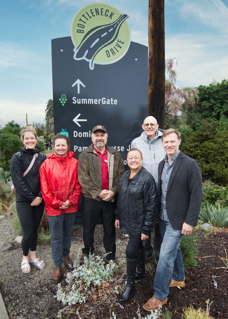 Erin Trainer, Jordan Kubek, Richard Barkwill, Sally Pierce, Doug Holmes, and Cameron posing in front of new signage