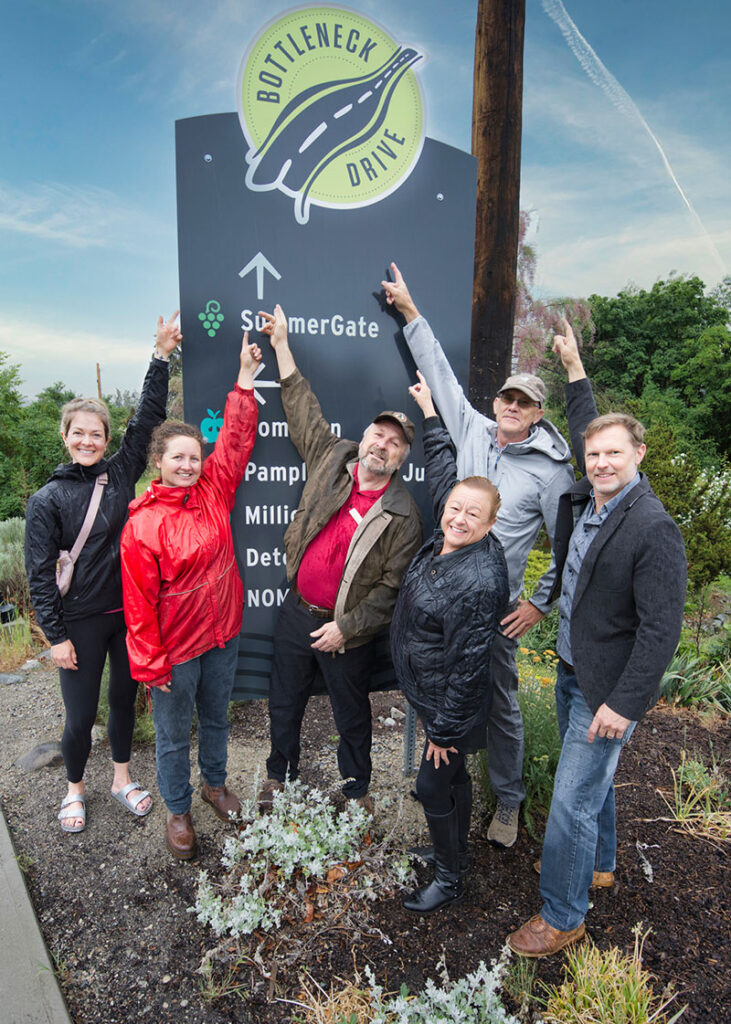 Erin Trainer, Jordan Kubek, Richard Barkwill, Sally Pierce, Doug Holmes, and Cameron playfully pointing at signage
