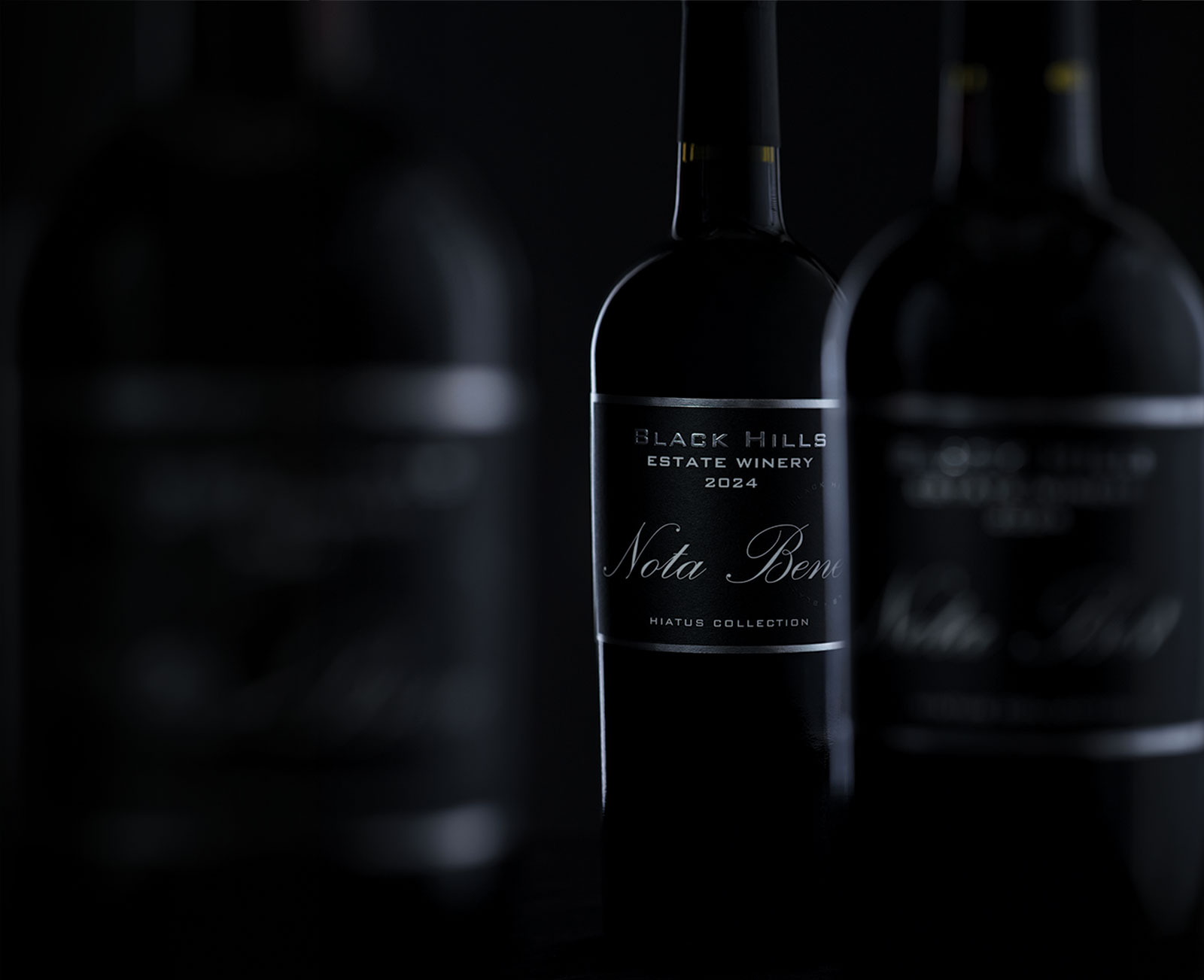 Bottles of wine against dark background and low, moody lighting