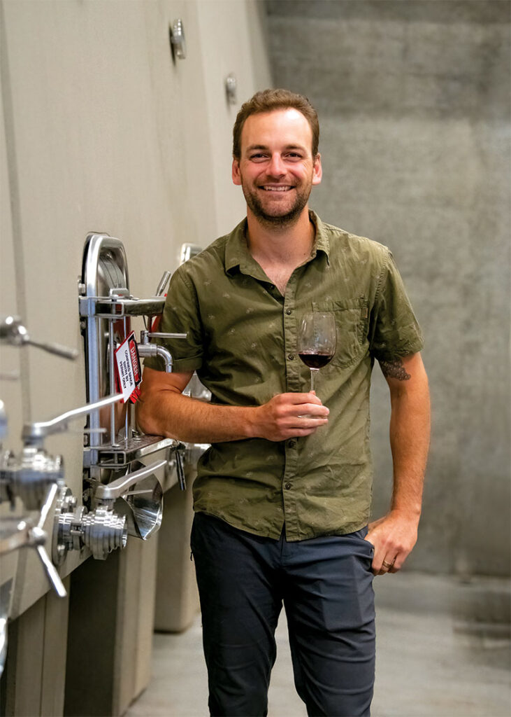 Ryan McKibbon posing for photo with glass of wine