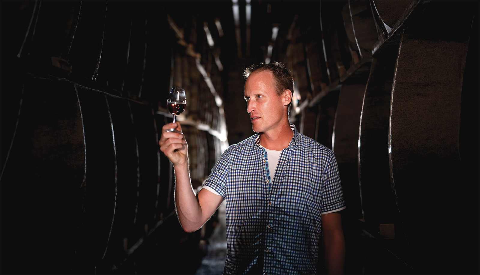 Don inspecting snifter of liquor in cellar