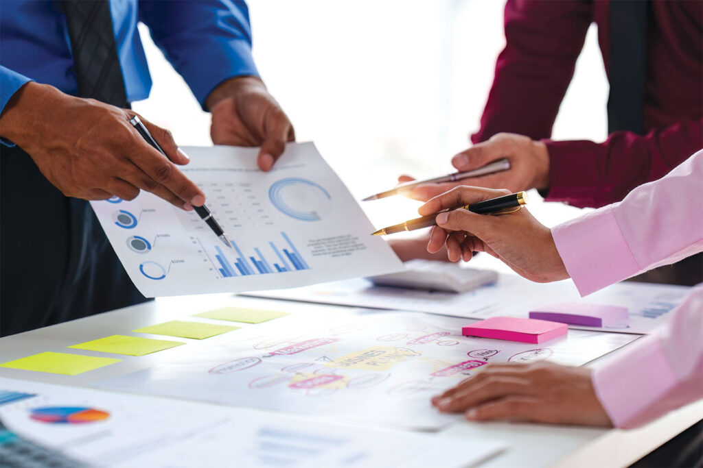 Group seemingly discussing data and reports that are on table