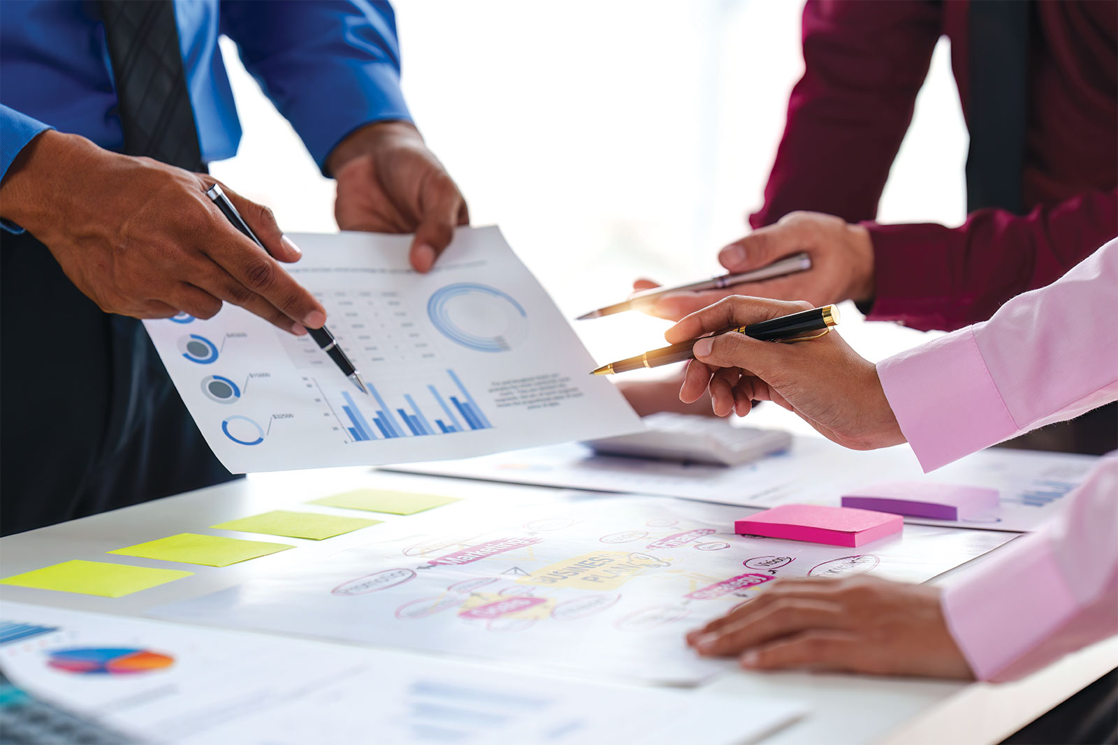 Group seemingly discussing data and reports that are on table