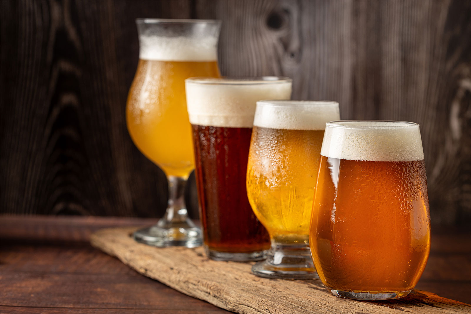 Four varieties of craft beer, lined up on a table