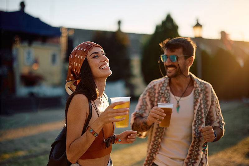 Carefree couple enjoying beer and dancing outdoors