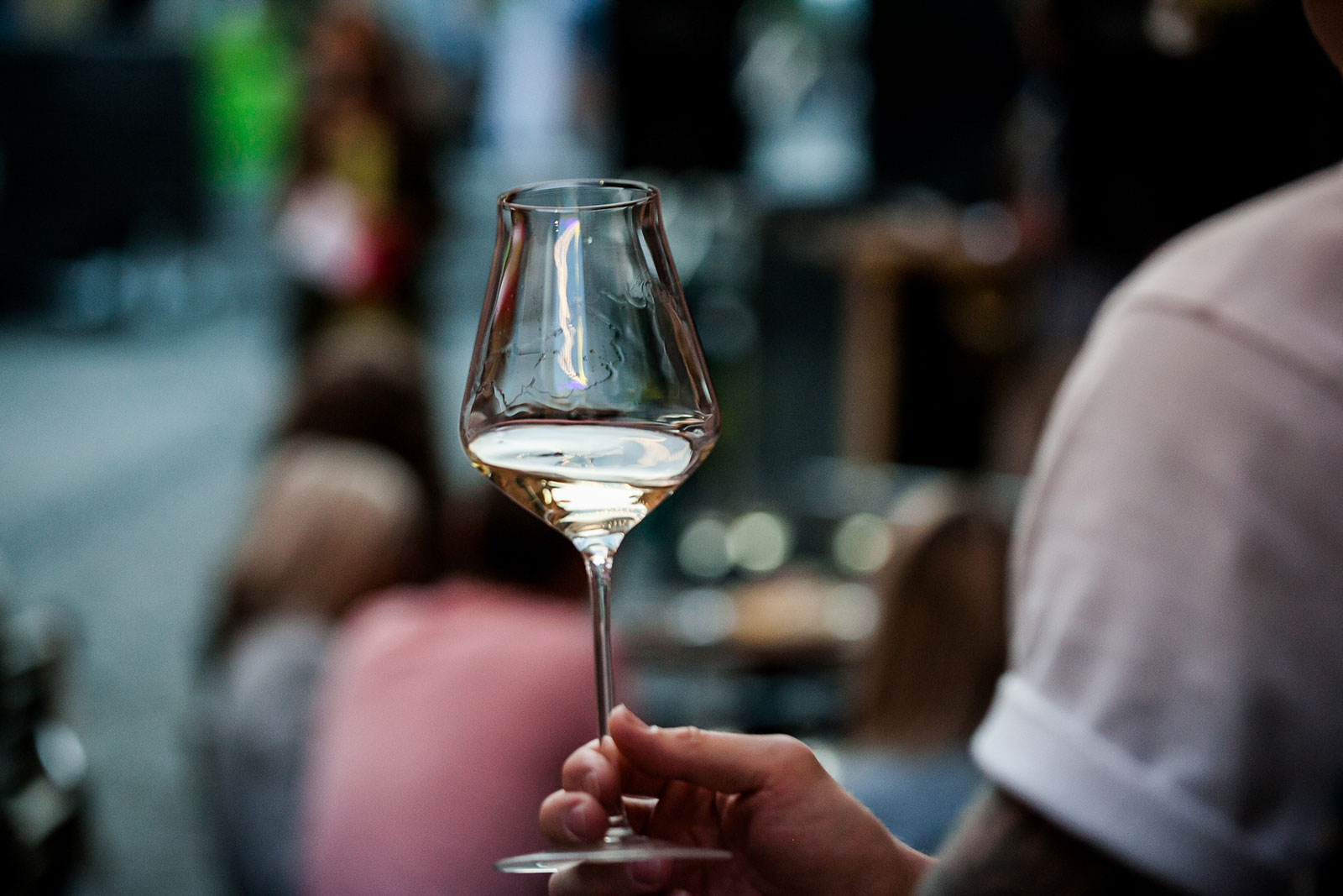 Close-up man's hand holding glass of white wine
